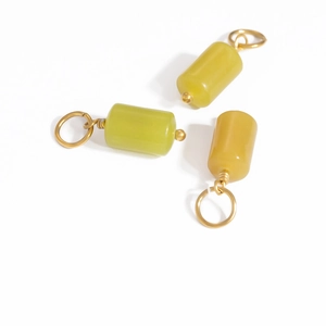 Macro view of cylindrical natural stone pendants with gold wire wrap for DIY jewelry