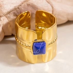 Detail of 18k gold plated stainless steel ring with blue stone and hammered texture