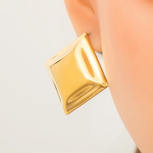 Polished 18k gold plated stainless steel square stud earrings on model's ear
