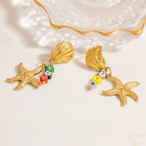 Gros plan détaillé de boucles d'oreilles étoile de mer dorées avec fleurs colorées