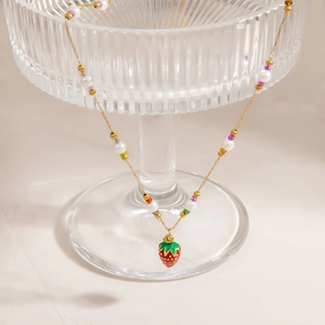 Detailed macro of strawberry pendant necklace with colorful beads and natural pearls