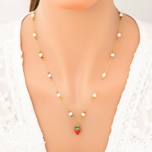 Natural freshwater pearl necklace with a red strawberry pendant on a model's neck