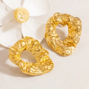 Detail of 18k gold plated chunky irregular hoop earrings with hammered metal texture