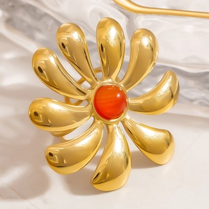 Polished 18k gold plated titanium flower ring with a vibrant red stone centerpiece