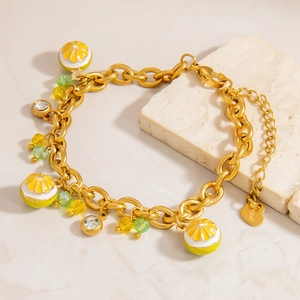 Bracelet chaîne en acier doré avec breloques citron et perles sur socle en pierre