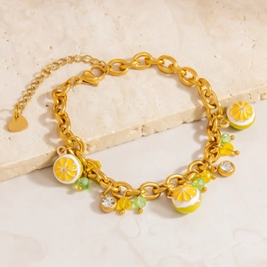 Vue macro détaillée du pendentif citron et des perles de cristal sur le bracelet en or