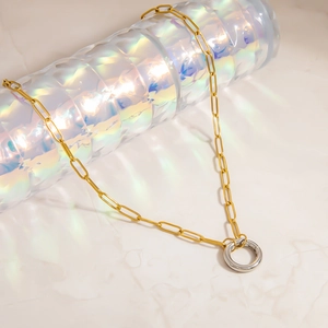 Detail of mixed-tone paperclip chain featuring a gold links and a silver spring clasp