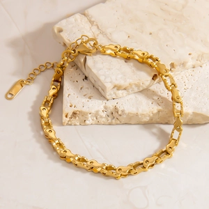 Dettaglio del bracciale a catena industriale dorata con chiusura a moschettone e estensione