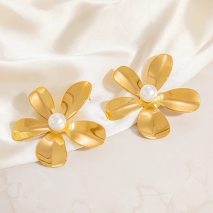 Macro detail of 18K gold plated flower earrings with pearl centers on satin silk