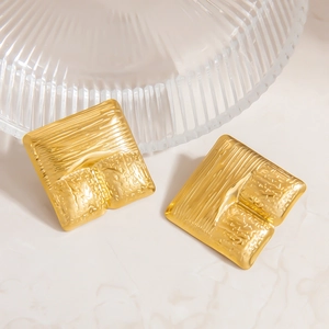 Detailed macro view of 18K gold plated stainless steel square earrings with molten texture