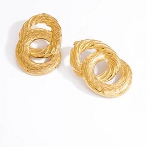 Detailed shot of interlocking gold twisted and hammered hoop earrings on a white base