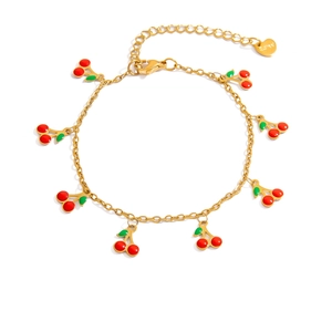 Detailed macro of golden chain bracelet featuring seven red enamel cherry charms and heart tag
