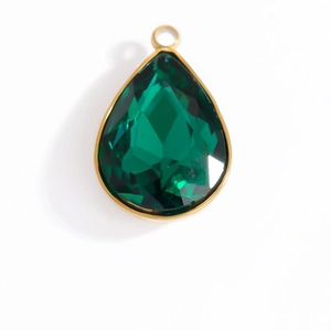 Macro detail of pear-shaped emerald crystal pendant with golden bezel and loop