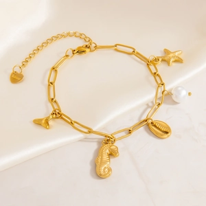 Bracelet en acier doré avec breloques étoile de mer perle et queue de baleine
