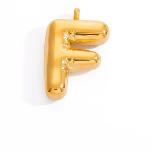 Detailed macro of 3D balloon style letter F gold pendant with textured folds