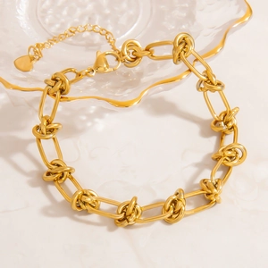 Détail d'un bracelet à grosses mailles plaqué or 18 carats avec fermoir et pendentif cœur