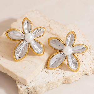 Detailed macro view of two-tone 18K gold and silver flower stud earrings with center pearl