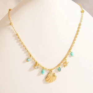 Dettaglio della collana con pendente a conchiglia e stella marina in oro 18K su manichino
