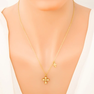 Dettaglio di una collana a due strati placcata oro 18 carati con croci e cristalli