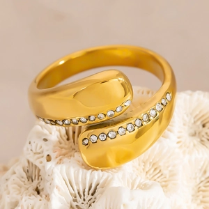 Minimalist gold plated stainless steel open ring with embedded zircons on white coral