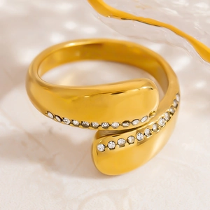 Macro shot of an adjustable 18K gold-plated S-shaped ring with pavé-set sparkling zircons