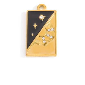 Macro view of gold stainless steel tarot sun and star pendant with black enamel