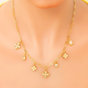 Detail van gouden titanium ketting met klaver, hart en druppelvormige hangers