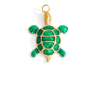 Macro view of a gold-plated turtle pendant with green enamel inlay and polished finish