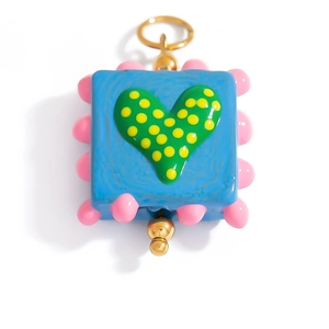 Detail of blue square glass heart pendant with colorful dots and gold-plated hardware
