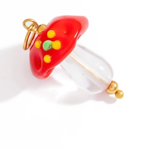 Detailed view of a handmade mushroom glass pendant with golden loop and colorful dots