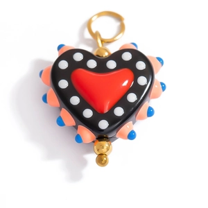 Macro detail of heart-shaped colorful resin pendant with gold metal ring and bead