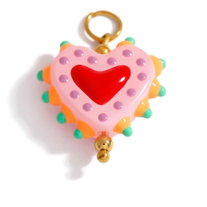 Macro detail of colorful glazed heart pendant with golden ring and pop art patterns