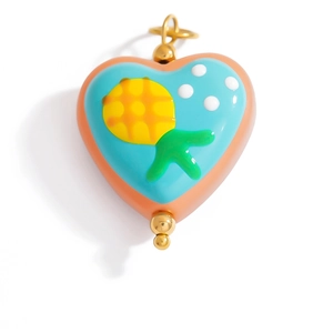 Macro view of colorful heart pendant with sun patterns and golden metal beads