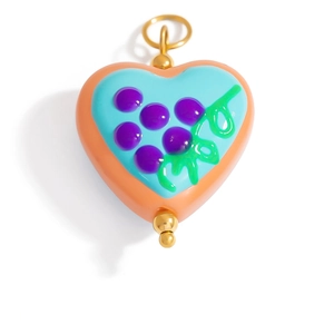 Detailed macro view of heart-shaped enamel pendant with grape pattern and gold loop