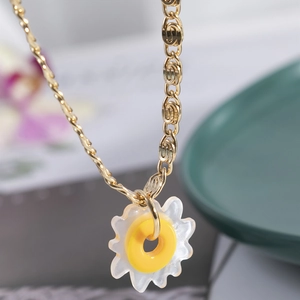 Elegant gold flower pendant necklace with white petals and yellow center on link chain