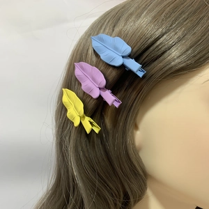 Matte finish leaf hair clips in blue, purple and yellow on wavy hair accessory