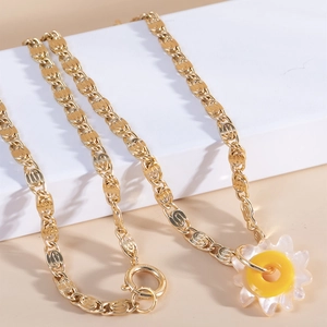 Elegant gold flower pendant necklace with irregular links on minimalist geometric stand