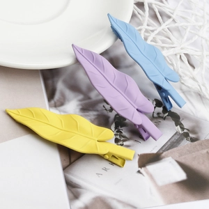 Set of three matte leaf hair clips in pastel yellow, purple, and blue metal finish