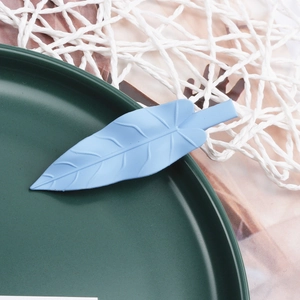 Detail of light blue matte leaf-shaped hair clip with elegant leaf vein textures