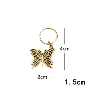 Detailed view of an antique gold butterfly pendant with hollow design for dreadlock rings