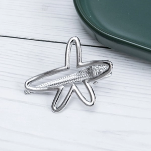 Close-up of a silver hollow star hair clip with anti-slip texture on a white wood background