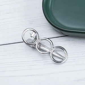 Detailed view of silver alloy geometric hair clip with three rings and duckbill clip back