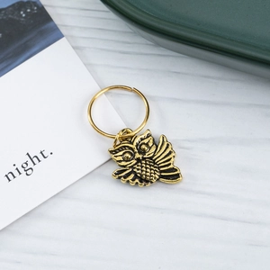 Vintage gold owl charm ring for dreadlocks hair decoration on a rustic wood background