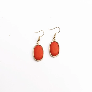 Nahaufnahme böhmischer Goldohrringe mit ovalen orange-roten Kunst-Türkissteinen
