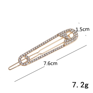 Macro-opname van een gouden veiligheidsspeld haarklem met afmetingen van 7,6 cm