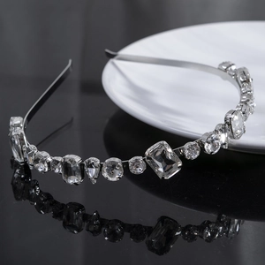 Elegant silver thin headband with sparkling geometric crystals on a black reflective surface