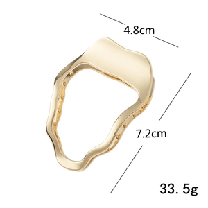 Pince à cheveux dorée en métal irrégulier au design fluide et minimaliste pour femme