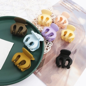 Set mit sieben matten Mini-Haarklammern in verschiedenen Pastellfarben auf einem Tablett