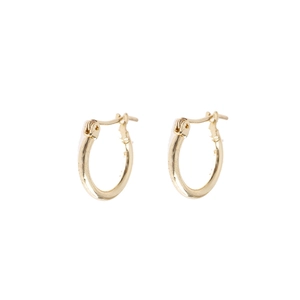 Detailed close-up of small golden huggie hoop earrings with secure click-top closure