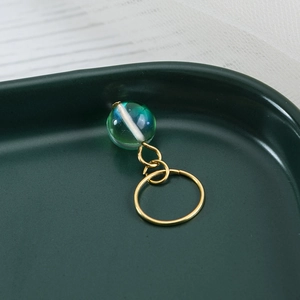 Golden spring ring pendant with a translucent blue-green bead for dreadlocks and hair styling
